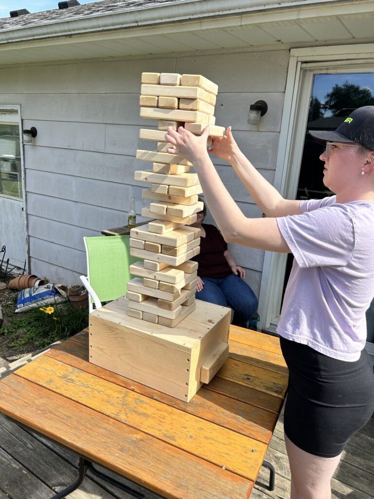 Playing Outdoor Jenga on a deck table